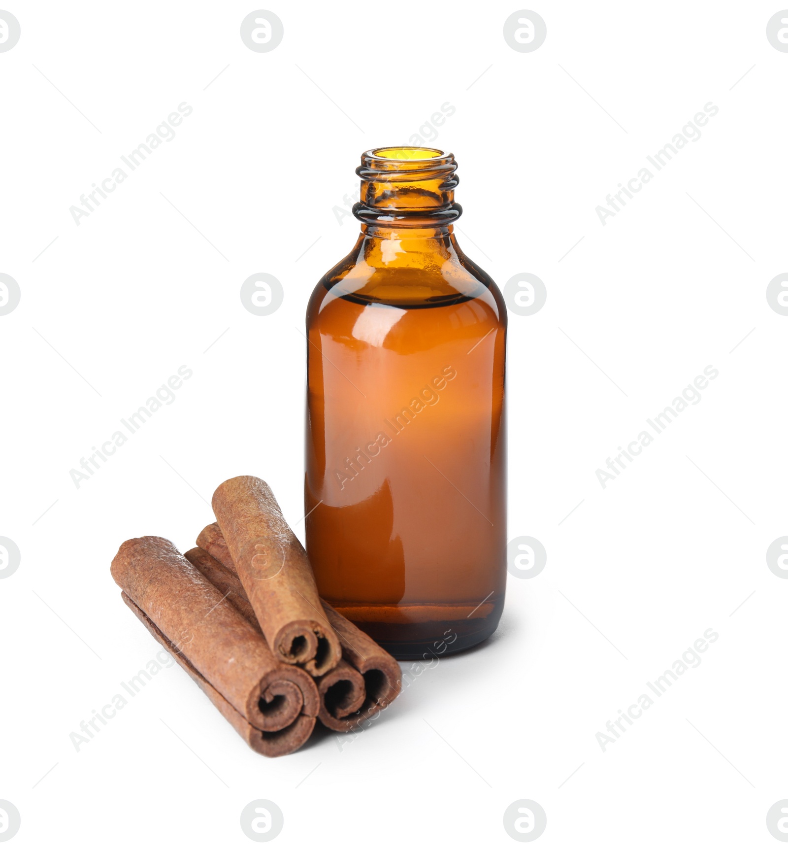 Photo of Bottle of essential oil and cinnamon sticks on white background