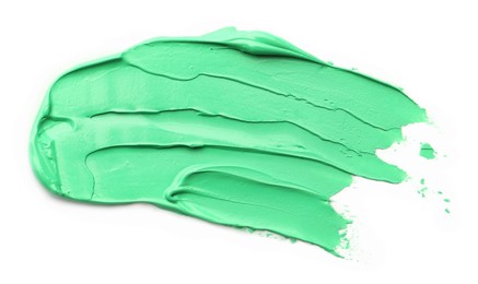 Photo of Green oil paint stroke on white background, top view