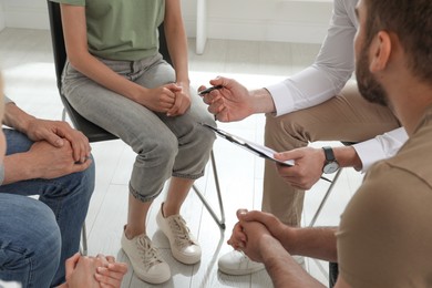 Photo of Psychotherapist working with group of drug addicted people at therapy session, closeup