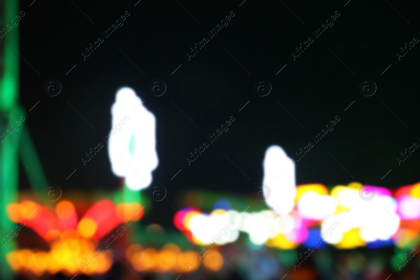 Photo of Blurred view of city street with festive lights at night. Bokeh effect