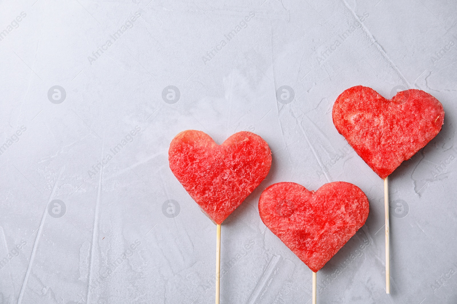 Photo of Flat lay composition with watermelon popsicles on grey background