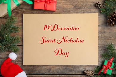 Image of 19 December Saint Nicholas Day. Flat lay composition with card on wooden table.