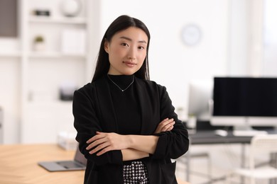 Portrait of beautiful businesswoman with crossed arms in office