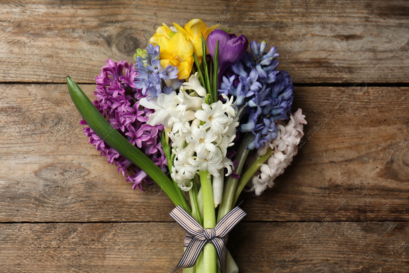 Photo of Beautiful spring flowers on wooden table, top view