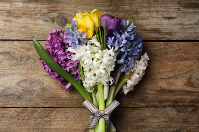 Beautiful spring flowers on wooden table, top view