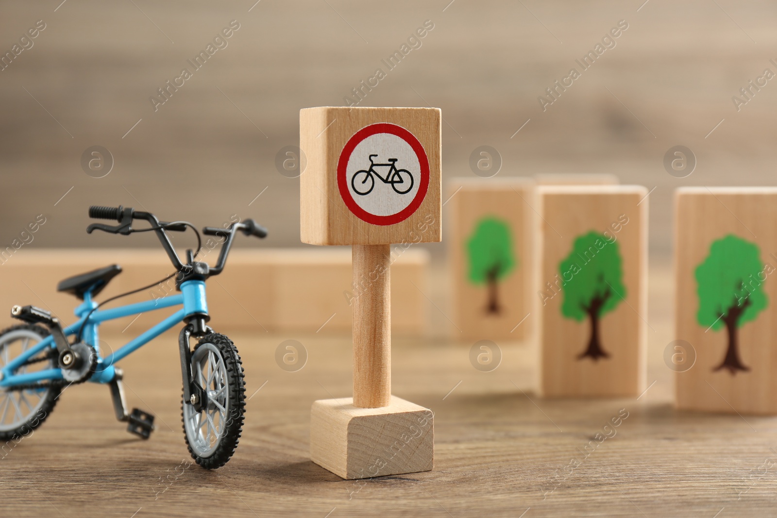 Photo of Traffic sign No cycling and toy bicycle on wooden table. Passing driving license exam