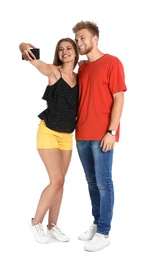 Photo of Happy young couple taking selfie on white background