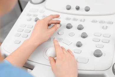 Photo of Sonographer operating modern ultrasound machine in clinic, closeup