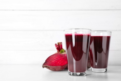 Photo of Glasses with fresh beet juice on table