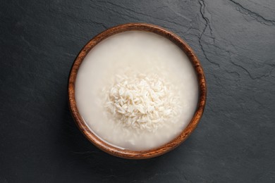 Photo of Rice soaked in water on black table, top view