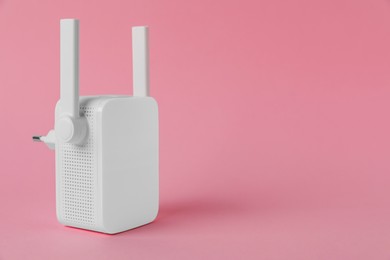 New modern Wi-Fi repeater on pink background, space for text