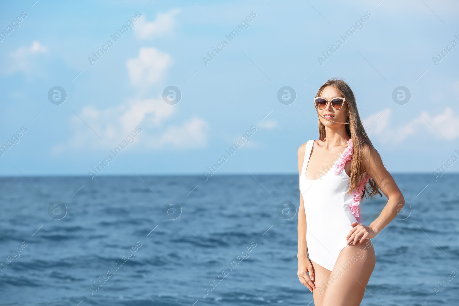 Photo of Attractive young woman in beautiful one-piece swimsuit on beach