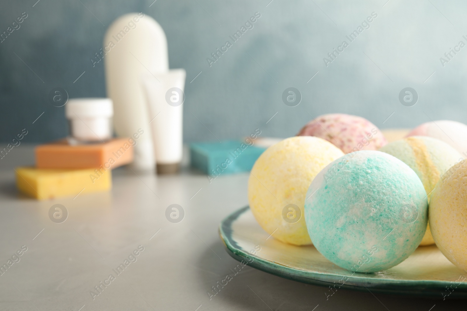Photo of Plate with colorful bath bombs on table. Space for text