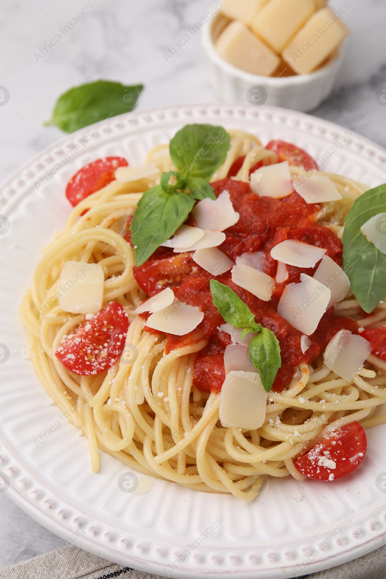 Photo of Tasty pasta with tomato sauce, cheese and basil on white table, closeup