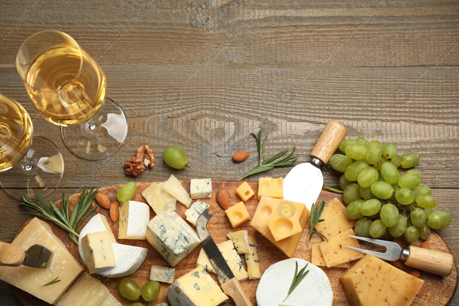 Photo of Flat lay composition with different sorts of cheese and knives on wooden table