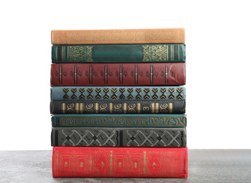 Photo of Stack of old vintage books on grey stone table against white background