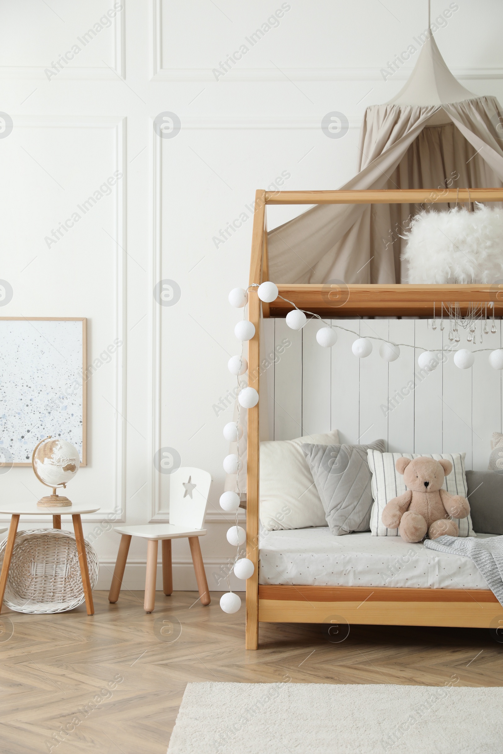 Photo of Stylish room for kid with house bed. Interior design