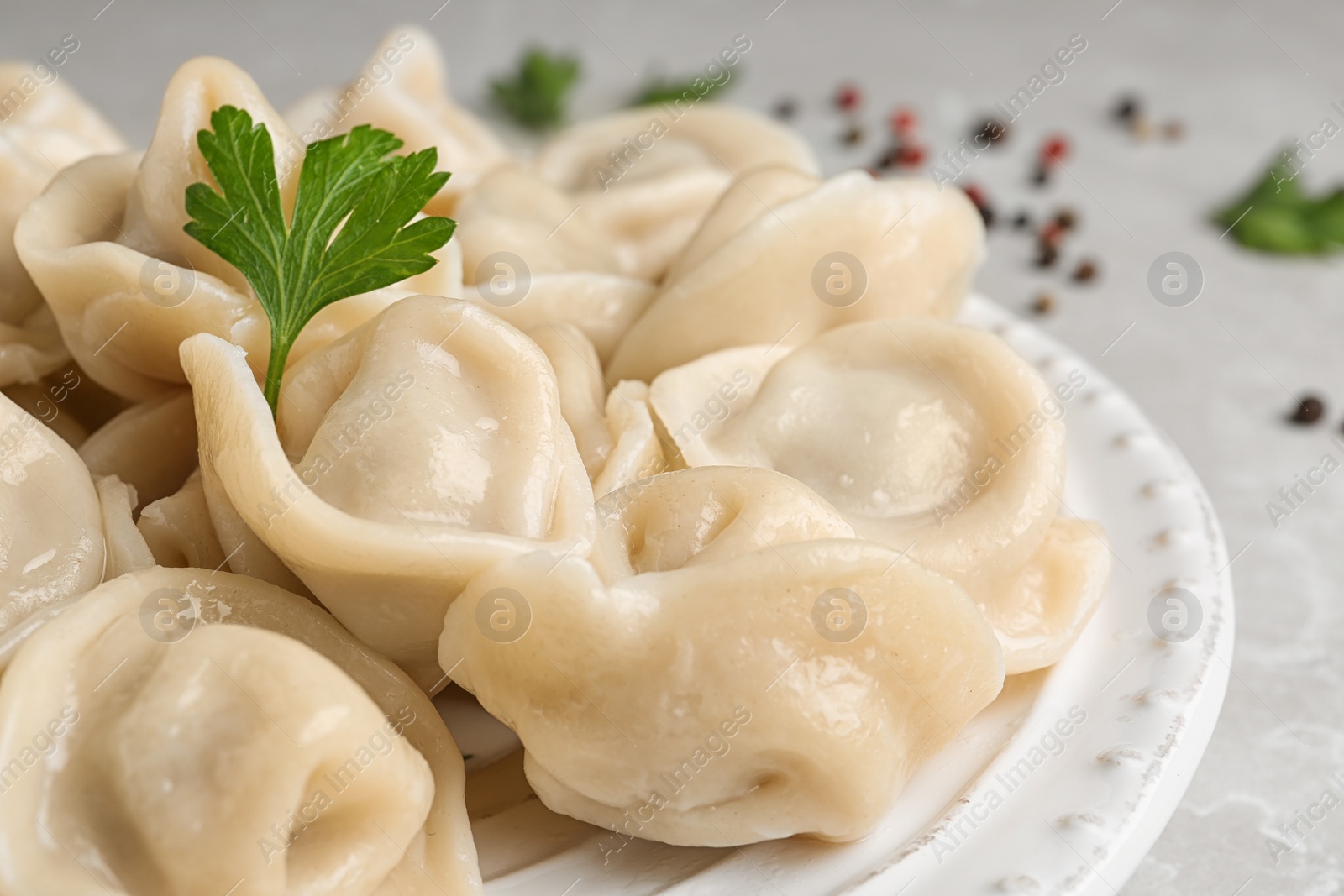 Photo of Tasty dumplings with parsley on plate, closeup view