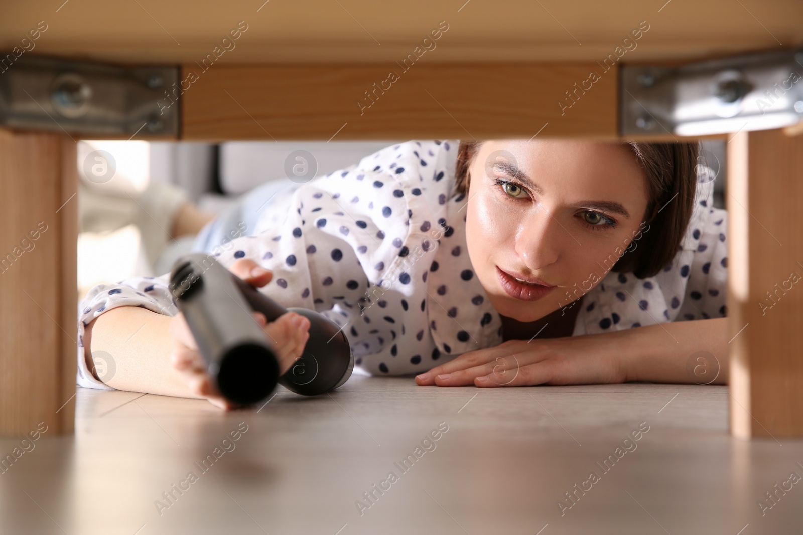 Photo of Young woman using vacuum cleaner at home