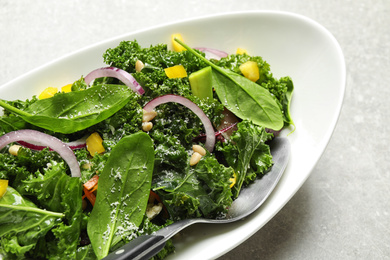 Photo of Tasty fresh kale salad on grey table, closeup