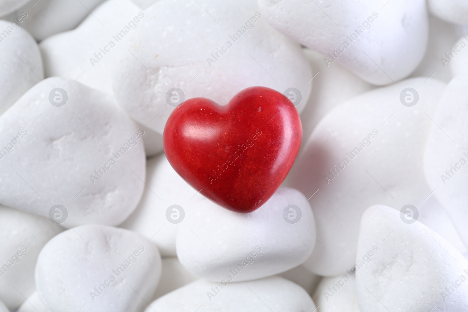 Photo of Decorative heart on white pebble stones, above view