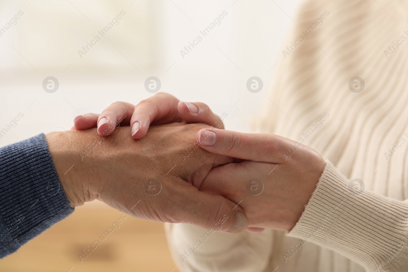 Photo of Trust and deal. Men joining hands on blurred background, closeup