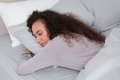 Photo of Beautiful African American woman sleeping in bed at home