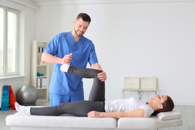 Physiotherapist working with female patient in clinic