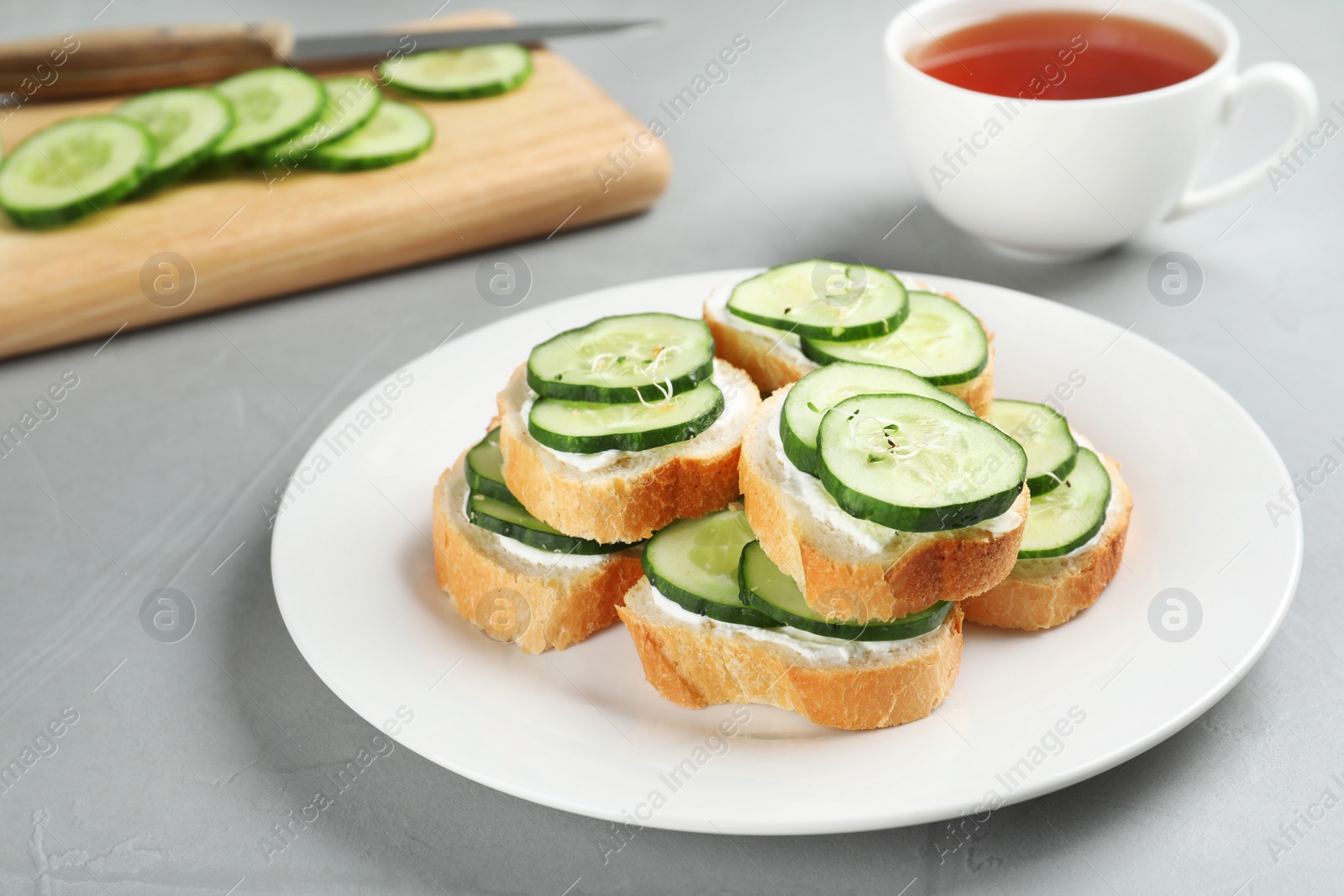 Photo of Plate with traditional English cucumber sandwiches on table