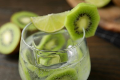Photo of Glass of refreshing drink with kiwi and lime on table, closeup