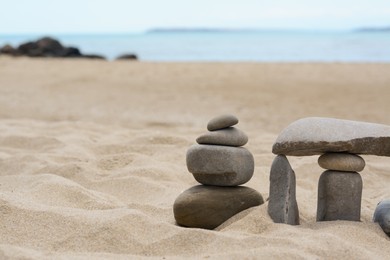 Photo of Stacksstones on beautiful sandy beach near sea, space for text