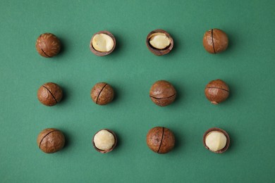 Photo of Tasty Macadamia nuts on green background, flat lay