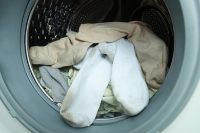 Photo of Many dirty socks in washing machine, closeup