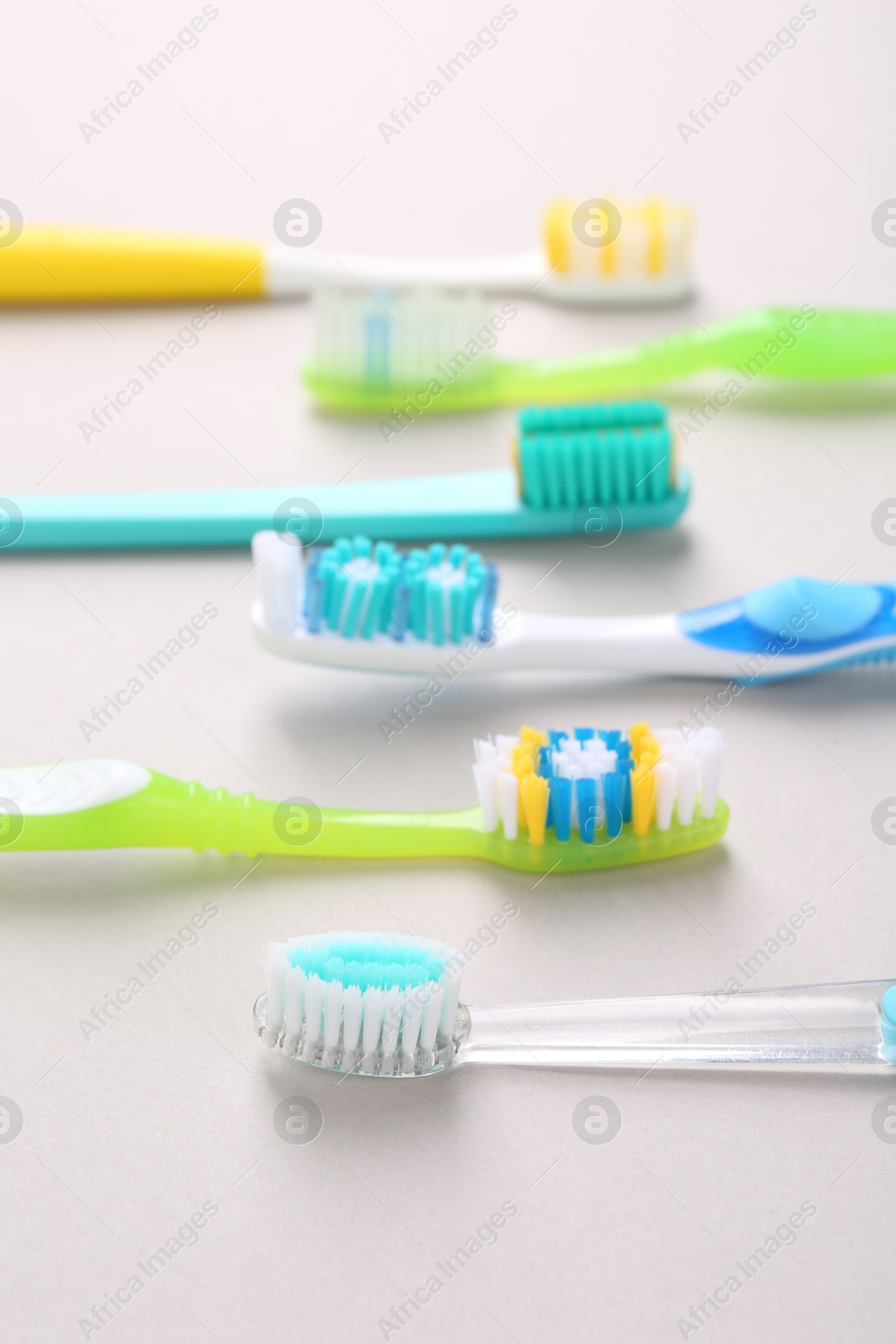 Photo of Many different toothbrushes on light background, closeup