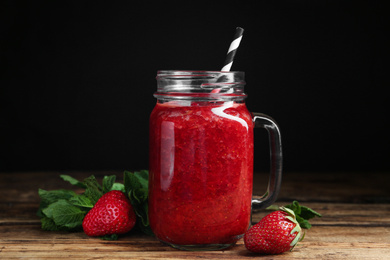 Photo of Tasty strawberry smoothie and mint on wooden table