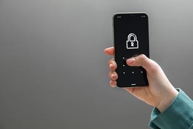 Photo of Woman unlocking smartphone with blocked screen on grey background, closeup. Space for text