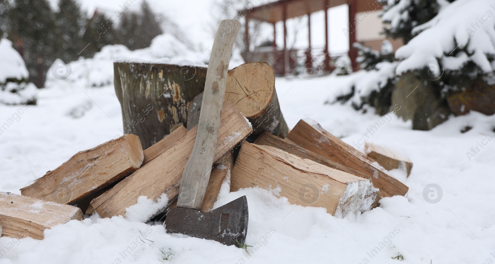 Photo of Axe, chopped wood and wooden log outdoors on winter day