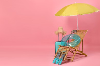 Photo of Deck chair, suitcase and beach accessories on pink background, space for text