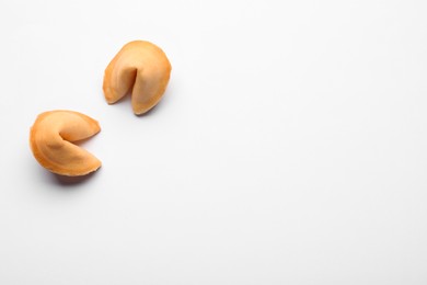 Photo of Tasty fortune cookies with predictions on white background, above view. Space for text