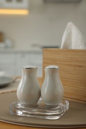 Photo of White ceramic salt and pepper shakers on wooden table, space for text