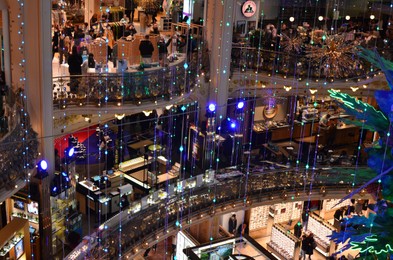 Photo of Paris, France - December 10, 2022: Crowded Galeries Lafayette Haussmann with beautiful Christmas decor