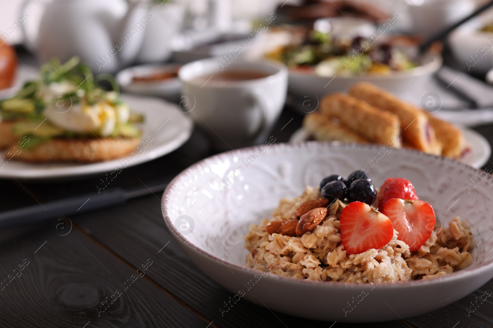 Photo of Oatmeal with fruits and nuts served on buffet table for brunch