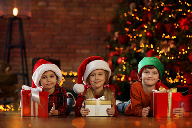 Photo of Little children with Christmas gifts at home. Presents from Santa Claus