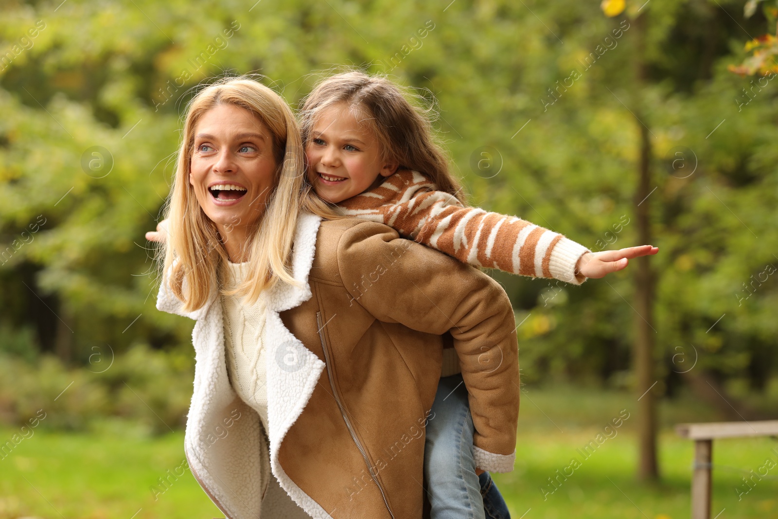 Photo of Happy mother having fun with her daughter in autumn park