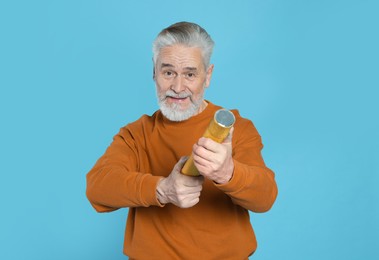 Photo of Man with party popper on light blue background