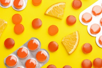 Photo of Many orange cough drops on pink background, flat lay