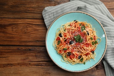 Photo of Delicious pasta with tomatoes, olives and parmesan cheese on wooden table, flat lay. Space for text