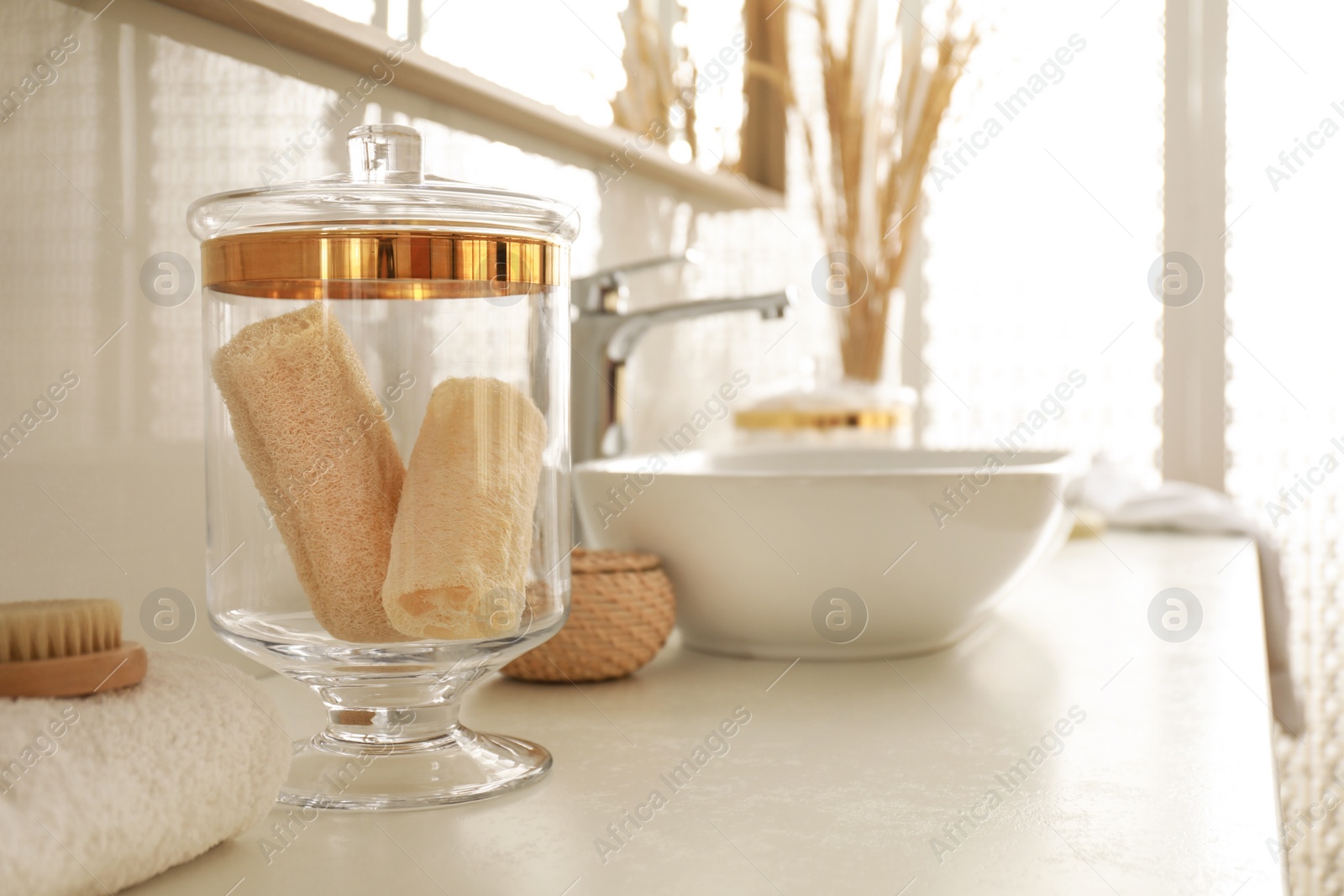 Photo of Jar with loofah sponges in modern bathroom interior