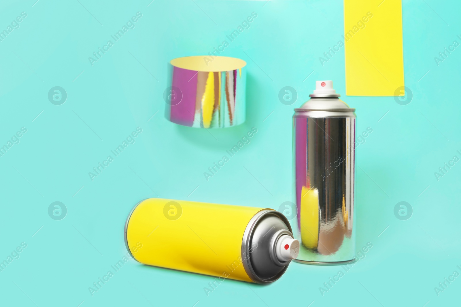 Photo of Cans of different spray paints on color background. Space for text