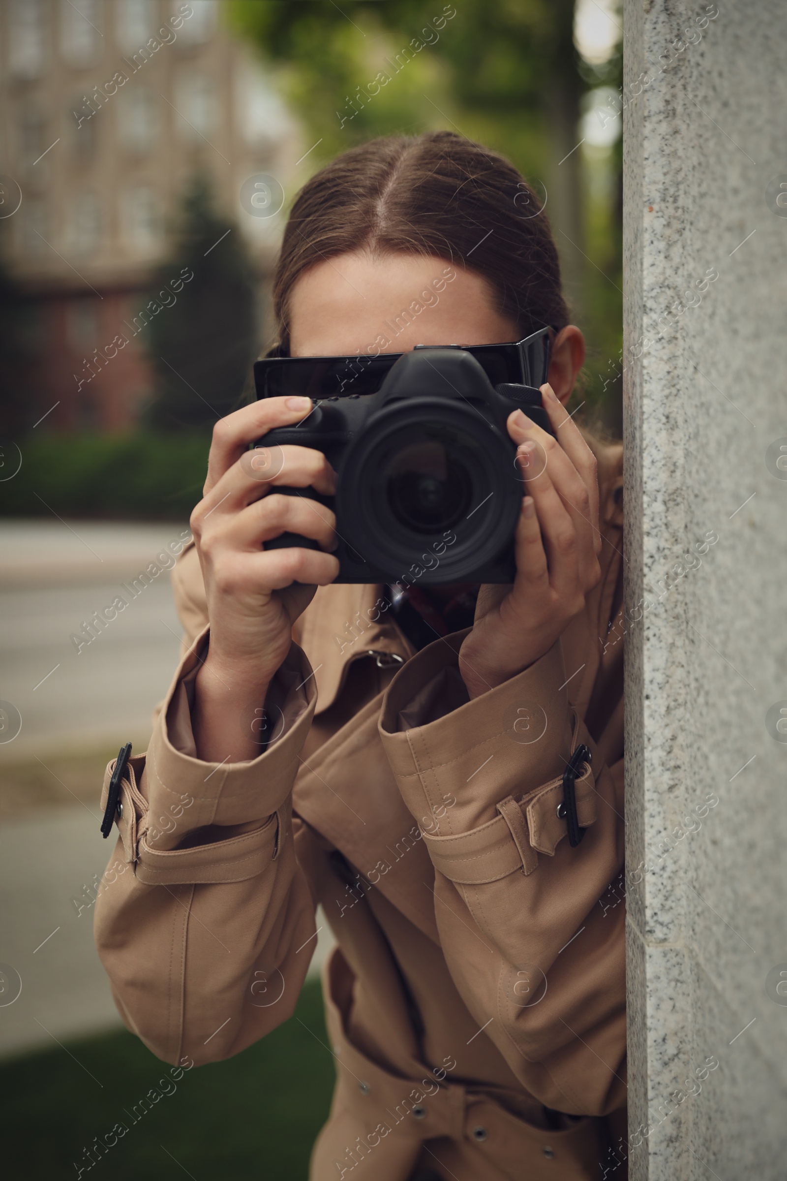 Photo of Private detective with modern camera spying on city street